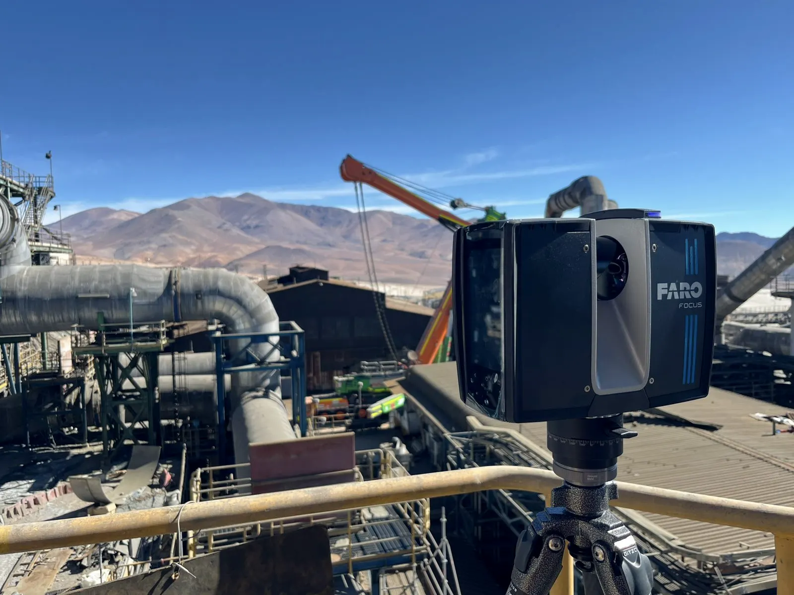 Escáner FARO Focus sobre trípode en una plataforma de planta, con la cordillera al fondo